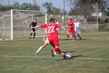ODESSA, UKRAINE - Ukrayna Şampiyonası 'ndaki birinci lig kulüplerinin dövüşü. FC BALKANY (Zorya) - FC VOLYNB (Lutsk) - kırmızı. Çimlerin üzerinde büyük futbol oynarken dramatik bir düello.