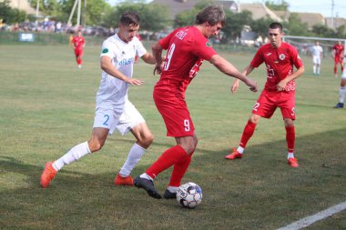 ODESSA, UKRAINE - Ukrayna Şampiyonası 'ndaki birinci lig kulüplerinin dövüşü. FC BALKANY (Zorya) - FC VOLYNB (Lutsk) - kırmızı. Çimlerin üzerinde büyük futbol oynarken dramatik bir düello.