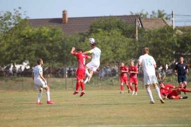 ODESSA, UKRAINE - Ukrayna Şampiyonası 'ndaki birinci lig kulüplerinin dövüşü. FC BALKANY (Zorya) - FC VOLYNB (Lutsk) - kırmızı. Çimlerin üzerinde büyük futbol oynarken dramatik bir düello.