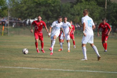ODESSA, UKRAINE - Ukrayna Şampiyonası 'ndaki birinci lig kulüplerinin dövüşü. FC BALKANY (Zorya) - FC VOLYNB (Lutsk) - kırmızı. Çimlerin üzerinde büyük futbol oynarken dramatik bir düello.