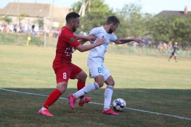 ODESSA, UKRAINE - Ukrayna Şampiyonası 'ndaki birinci lig kulüplerinin dövüşü. FC BALKANY (Zorya) - FC VOLYNB (Lutsk) - kırmızı. Çimlerin üzerinde büyük futbol oynarken dramatik bir düello.