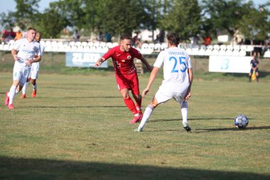 ODESSA, UKRAINE - Ukrayna Şampiyonası 'ndaki birinci lig kulüplerinin dövüşü. FC BALKANY (Zorya) - FC VOLYNB (Lutsk) - kırmızı. Çimlerin üzerinde büyük futbol oynarken dramatik bir düello.