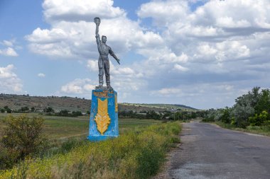 Yoldaki eski Sovyet heykeli İşçi ve Toplu Çiftliği ölmekte olan bir Ukrayna köyüne giriş sunuyor. Eski Sovyet anıtı, Odessa. Sovyet döneminin Ukrayna 'daki mirası.