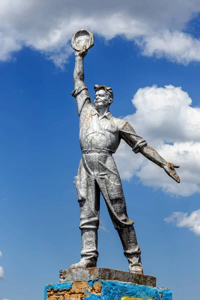 The old Soviet sculpture Worker and Collective Farm on road offers entry into a dying Ukrainian village. Old Soviet monument, Odessa. Legacy of Soviet period in Ukraine.