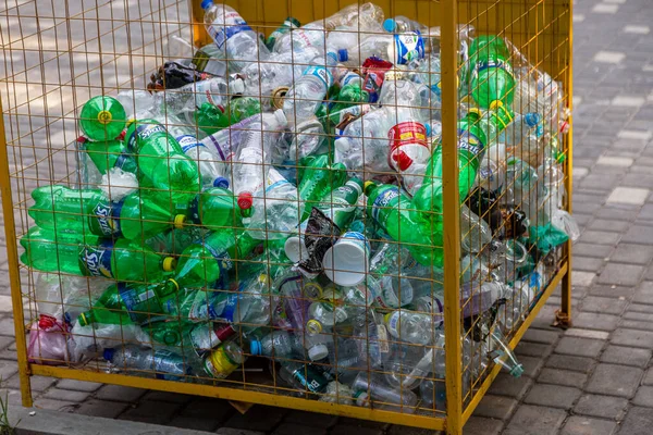 ODESSA, UKRAINE -CIRKA 2017: Boş kullanılmış plastik şişeler plastik atık ve geri dönüşüm için özel bir ağ metal kapta toplanır