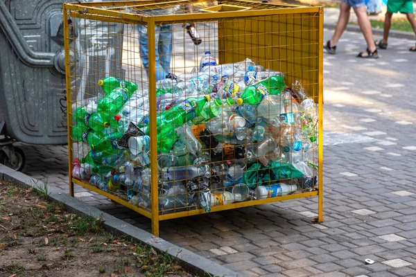 ODESSA, UKRAINE -CIRKA 2017: Boş kullanılmış plastik şişeler plastik atık ve geri dönüşüm için özel bir ağ metal kapta toplanır