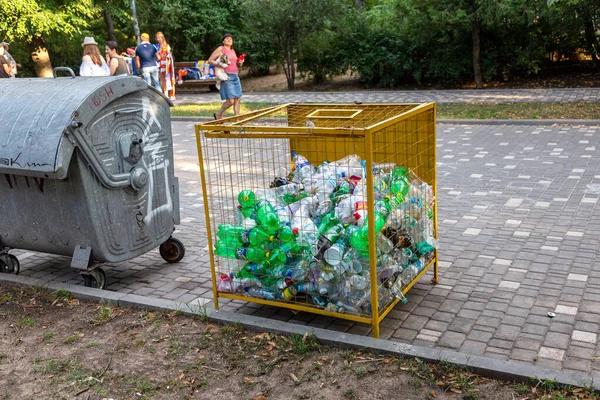 ODESSA, UKRAINE -CIRKA 2017: Boş kullanılmış plastik şişeler plastik atık ve geri dönüşüm için özel bir ağ metal kapta toplanır