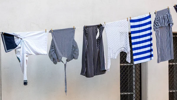 洗濯はロープで乾く ウェット航海服 ネイビーストライプシャツ ベストはロープで乾燥しています 都市景観 — ストック写真