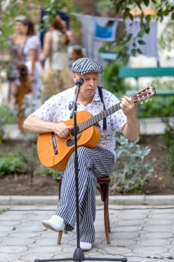 Odessa, Ukrayna - CIRCA 2020: Virüs salgını sırasında bir evin avlusunda sokak müzisyenlerinin ev konseri. Sokak müzisyenleri açık havada konser veriyor.