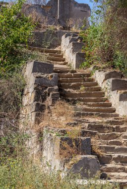 Eski, açık, taştan bir merdiven. Taş, eski merdivenlerin çimento basamaklarında yıpranma ve yıpranma izleri var. Eski taş bir merdiven, eski kırık basamaklar. Seçici odak