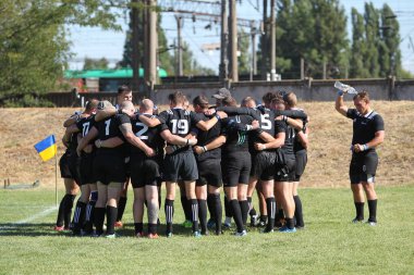 Odessa, Ukrayna - 29 Ağustos 2020: Odessa Milli Takımı CREDO (kırmızı) - Kiev Antares (siyah) ragbi 7 'leri. Top için erkek rugby oyuncularının sert agresif dövüşü. Stadyumun yeşil çimenlik alanında dinamik bir oyun