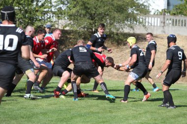Odessa, Ukrayna - 29 Ağustos 2020: Odessa Milli Takımı CREDO (kırmızı) - Kiev Antares (siyah) ragbi 7 'leri. Top için erkek rugby oyuncularının sert agresif dövüşü. Stadyumun yeşil çimenlik alanında dinamik bir oyun