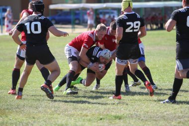 Odessa, Ukrayna - 29 Ağustos 2020: Odessa Milli Takımı CREDO (kırmızı) - Kiev Antares (siyah) ragbi 7 'leri. Top için erkek rugby oyuncularının sert agresif dövüşü. Stadyumun yeşil çimenlik alanında dinamik bir oyun