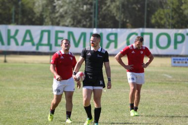 Odessa, Ukrayna - 29 Ağustos 2020: Odessa Milli Takımı CREDO (kırmızı) - Kiev Antares (siyah) ragbi 7 'leri. Top için erkek rugby oyuncularının sert agresif dövüşü. Stadyumun yeşil çimenlik alanında dinamik bir oyun