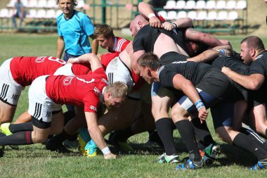 Odessa, Ukrayna - 29 Ağustos 2020: Odessa Milli Takımı CREDO (kırmızı) - Kiev Antares (siyah) ragbi 7 'leri. Top için erkek rugby oyuncularının sert agresif dövüşü. Stadyumun yeşil çimenlik alanında dinamik bir oyun