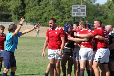 Odessa, Ukrayna - 29 Ağustos 2020: Odessa Milli Takımı CREDO (kırmızı) - Kiev Antares (siyah) ragbi 7 'leri. Top için erkek rugby oyuncularının sert agresif dövüşü. Stadyumun yeşil çimenlik alanında dinamik bir oyun