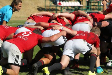 Odessa, Ukrayna - 29 Ağustos 2020: Odessa Milli Takımı CREDO (kırmızı) - Kiev Antares (siyah) ragbi 7 'leri. Top için erkek rugby oyuncularının sert agresif dövüşü. Stadyumun yeşil çimenlik alanında dinamik bir oyun