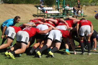 Odessa, Ukrayna - 29 Ağustos 2020: Odessa Milli Takımı CREDO (kırmızı) - Kiev Antares (siyah) ragbi 7 'leri. Top için erkek rugby oyuncularının sert agresif dövüşü. Stadyumun yeşil çimenlik alanında dinamik bir oyun
