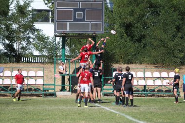 Odessa, Ukrayna - 29 Ağustos 2020: Odessa Milli Takımı CREDO (kırmızı) - Kiev Antares (siyah) ragbi 7 'leri. Top için erkek rugby oyuncularının sert agresif dövüşü. Stadyumun yeşil çimenlik alanında dinamik bir oyun