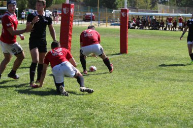 Odessa, Ukrayna - 29 Ağustos 2020: Odessa Milli Takımı CREDO (kırmızı) - Kiev Antares (siyah) ragbi 7 'leri. Top için erkek rugby oyuncularının sert agresif dövüşü. Stadyumun yeşil çimenlik alanında dinamik bir oyun