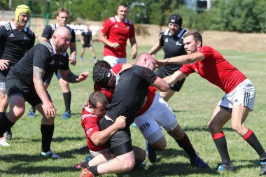 Odessa, Ukrayna - 29 Ağustos 2020: Odessa Milli Takımı CREDO (kırmızı) - Kiev Antares (siyah) ragbi 7 'leri. Top için erkek rugby oyuncularının sert agresif dövüşü. Stadyumun yeşil çimenlik alanında dinamik bir oyun