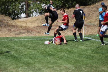 Odessa, Ukrayna - 29 Ağustos 2020: Odessa Milli Takımı CREDO (kırmızı) - Kiev Antares (siyah) ragbi 7 'leri. Top için erkek rugby oyuncularının sert agresif dövüşü. Stadyumun yeşil çimenlik alanında dinamik bir oyun