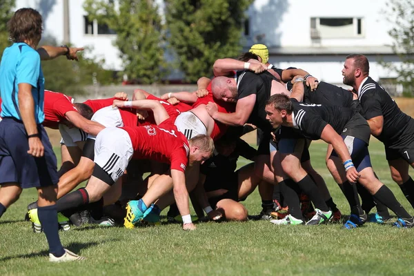 Odessa, Ukrayna - 29 Ağustos 2020: Odessa Milli Takımı CREDO (kırmızı) - Kiev Antares (siyah) ragbi 7 'leri. Top için erkek rugby oyuncularının sert agresif dövüşü. Stadyumun yeşil çimenlik alanında dinamik bir oyun