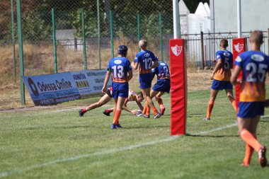 Odessa, Ukrayna - 29 Ağustos 2020: Odessa Milli Takımı CREDO (kırmızı) - Kiev Darnitsa (mavi) ragbi - 7. Top için erkek rugby oyuncularının sert agresif mücadelesi. Stadyumun yeşil çimlerinde dinamik bir oyun