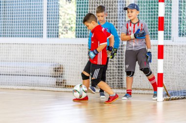 ODESSA, UKRAINE-CIRCA-2020: Çocuklar mini futbol oynuyor. Futsal kaleci kapıda duruyor. Futbolcuların, futsal kalecilerinin, futbol sahasındaki çocukların spor eğitimi.