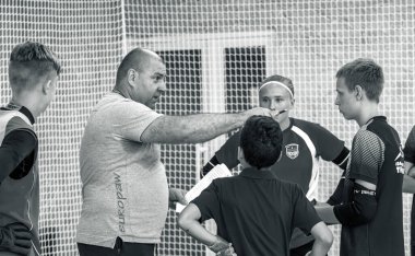 ODESSA, UKRAINE-CIRCA-2020: Çocuklar mini futbol oynuyor. Futsal kaleci kapıda duruyor. Futbolcuların, futsal kalecilerinin, futbol sahasındaki çocukların spor eğitimi.