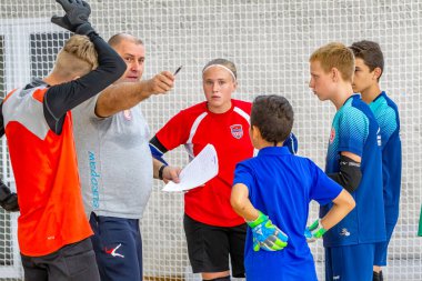 ODESSA, UKRAINE-CIRCA-2020: Çocuklar mini futbol oynuyor. Futsal kaleci kapıda duruyor. Futbolcuların, futsal kalecilerinin, futbol sahasındaki çocukların spor eğitimi.