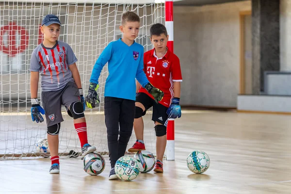 ODESSA, UKRAINE-CIRCA-2020: Çocuklar mini futbol oynuyor. Futsal kaleci kapıda duruyor. Futbolcuların, futsal kalecilerinin, futbol sahasındaki çocukların spor eğitimi.