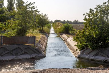 Beton bir duvardaki tarım kanalı veya sulama kanalı çiftçinin kurak tarım alanlarındaki tarım arazisine doğrudan su verir.