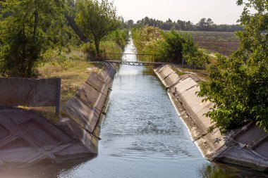 Beton bir duvardaki tarım kanalı veya sulama kanalı çiftçinin kurak tarım alanlarındaki tarım arazisine doğrudan su verir.