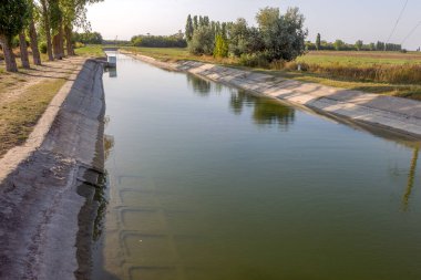 Beton bir duvardaki tarım kanalı veya sulama kanalı çiftçinin kurak tarım alanlarındaki tarım arazisine doğrudan su verir.
