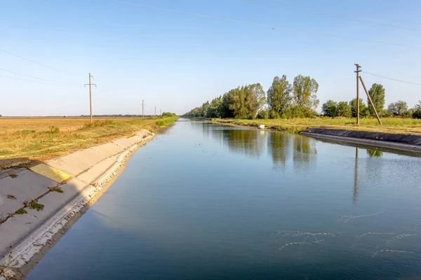 コンクリート壁の農業用運河または灌漑用運河危険な農業の乾燥地帯の農家の農地に直接水 — ストック写真
