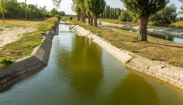 Beton bir duvardaki tarım kanalı veya sulama kanalı çiftçinin kurak tarım alanlarındaki tarım arazisine doğrudan su verir.