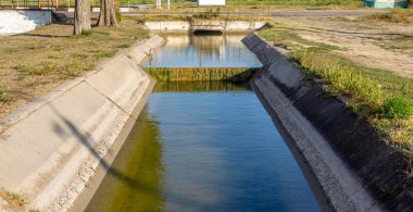 Beton bir duvardaki tarım kanalı veya sulama kanalı çiftçinin kurak tarım alanlarındaki tarım arazisine doğrudan su verir.