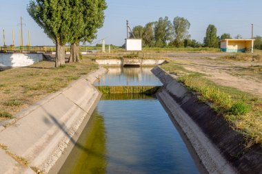 Beton bir duvardaki tarım kanalı veya sulama kanalı çiftçinin kurak tarım alanlarındaki tarım arazisine doğrudan su verir.