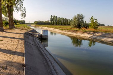 Beton bir duvardaki tarım kanalı veya sulama kanalı çiftçinin kurak tarım alanlarındaki tarım arazisine doğrudan su verir.