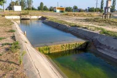 Beton bir duvardaki tarım kanalı veya sulama kanalı çiftçinin kurak tarım alanlarındaki tarım arazisine doğrudan su verir.