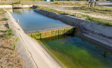 Beton bir duvardaki tarım kanalı veya sulama kanalı çiftçinin kurak tarım alanlarındaki tarım arazisine doğrudan su verir.