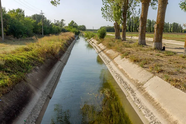Beton bir duvardaki tarım kanalı veya sulama kanalı çiftçinin kurak tarım alanlarındaki tarım arazisine doğrudan su verir.