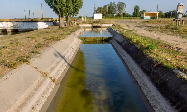 Beton bir duvardaki tarım kanalı veya sulama kanalı çiftçinin kurak tarım alanlarındaki tarım arazisine doğrudan su verir.