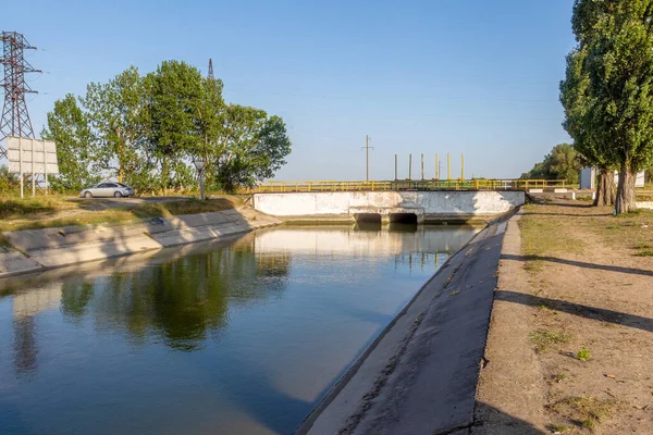 Beton bir duvardaki tarım kanalı veya sulama kanalı çiftçinin kurak tarım alanlarındaki tarım arazisine doğrudan su verir.