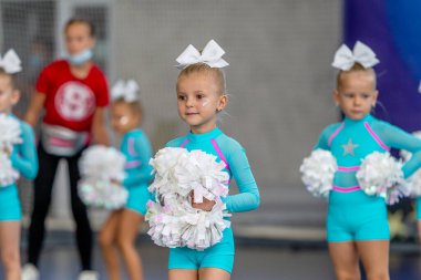 ODESSA, UKRAINE - 20 Eylül 2020: Çocuk Amigoluğu Şampiyonası. Genç ponpon kızlar şehrin spor salonundaki ponpon kız şampiyonasında gösteri yapıyorlar. Çocuk sporları, sağlıklı yaşam tarzı.