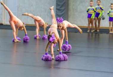 ODESSA, UKRAINE - 20 Eylül 2020: Çocuk Amigoluğu Şampiyonası. Genç ponpon kızlar şehrin spor salonundaki ponpon kız şampiyonasında gösteri yapıyorlar. Çocuk sporları, sağlıklı yaşam tarzı.