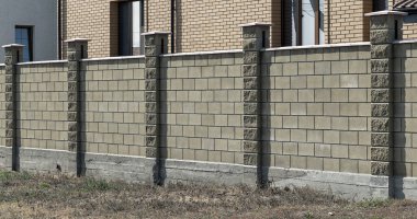 Prefabrik beton, taş, tuğla yeni, modern, pahalı, sokak sokak çitleri. Çit duvarı, kabartmalı yol macunuyla kaplıdır. Metin, zenginlik konsepti, koruma; güvenilirlik