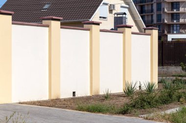 Prefabrik beton, taş, tuğla yeni, modern, pahalı, sokak sokak çitleri. Çit duvarı, kabartmalı yol macunuyla kaplıdır. Metin, zenginlik konsepti, koruma; güvenilirlik
