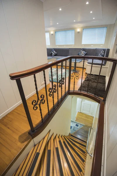 Interior design furnishing decor of the salon area in a large luxury motor yacht with wooden staircase